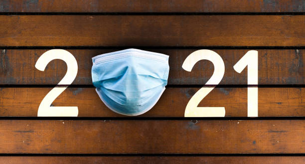 istock Year 2021 on wooden table with Surgical Face Mask. 1271932234