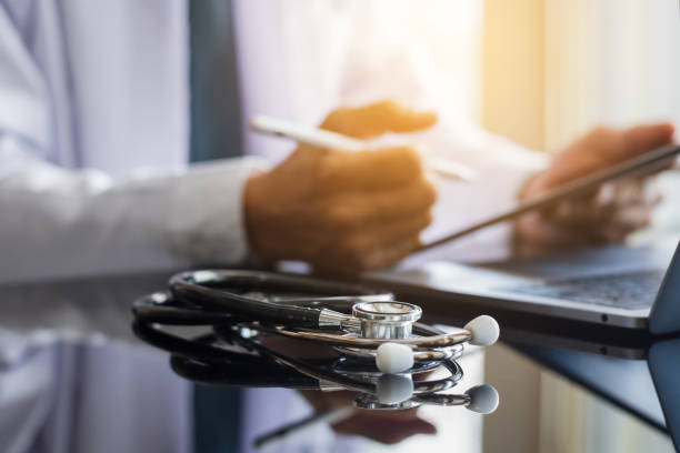istock Doctor man in white coat hand using modern digital tablet, work on laptop computer. 1271932688