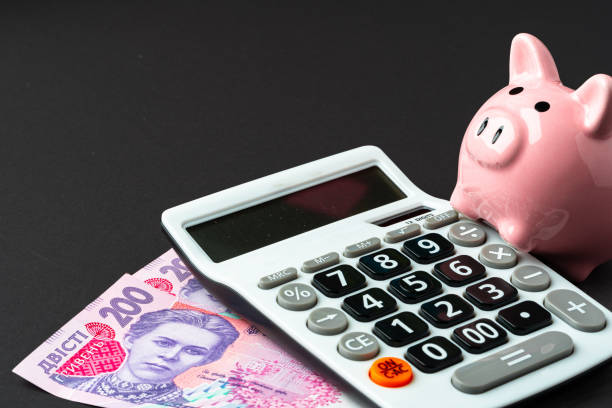 Calculator with piggy bank and money, ukrainian hryvnas Calculator with piggy bank and money, ukrainian hryvnas ukrainian currency stock pictures, royalty-free photos & images