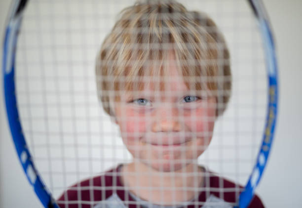 istock A young boy pose in front of a white screen with an old tennis racket 1271935201