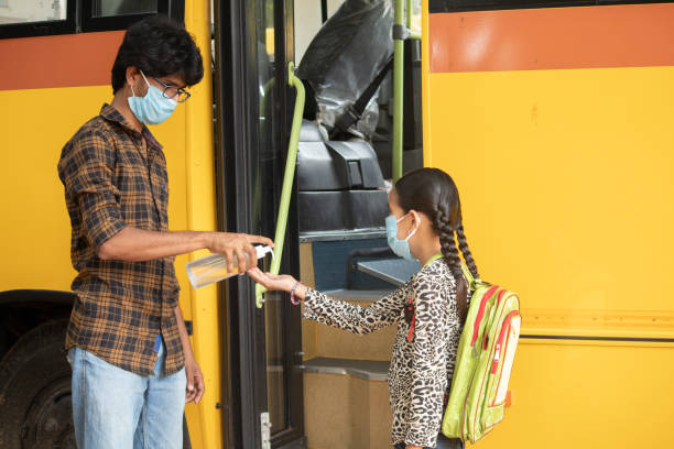 istock Teacher Providing hand sanitizer to students before going or getting inside the school bus while maintaining social distance as coronavirus or covid-19 safety measures. 1271935662