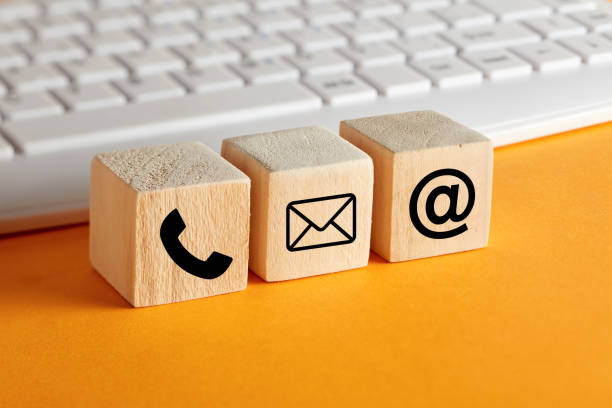 istock OOnline business communication symbols on wooden cubes with computer keyboard background. Contact us or e-mail marketing concept 1271935687