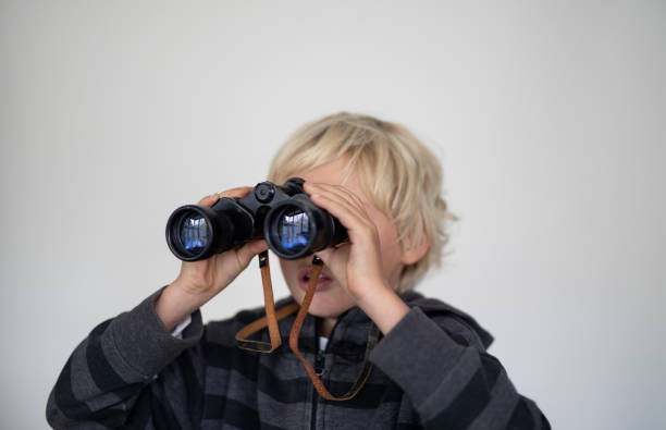 istock A young boy pose in front of a white screen with a binocular. 1271936627