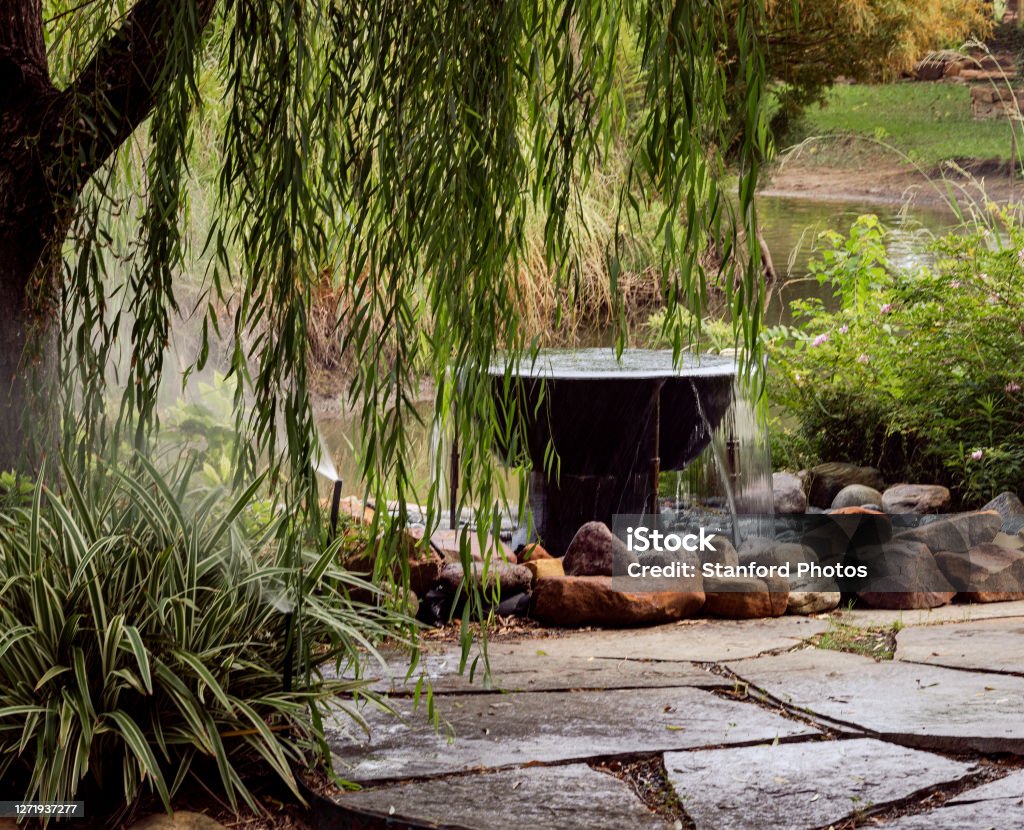 Zen Garden Flowing water from a large pot in a zen garden Japanese Rock Garden Stock Photo