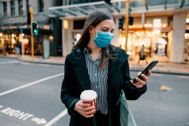 istock young businesswoman with protective face mask using smartphone while commuting in the business district 1271939627
