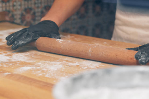 istock Chef hands in black gloves prepares dough close up 1271940266