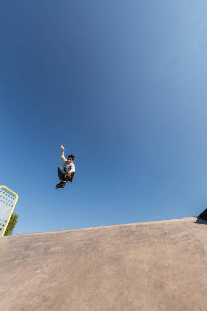 istock a roller skater jumps a ramp doing a trick in a skate park 1271940820