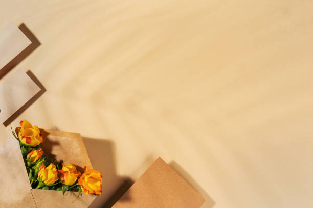 Craft paper envelope with yellow roses on beige background