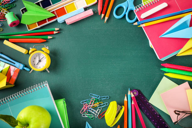 istock Frame of various school stationery on green blackboard background. Top view. Copy space. 1271943611
