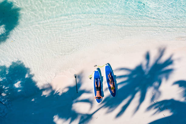 istock Young couple enjoying sun under palm trees in Maldives 1271943867