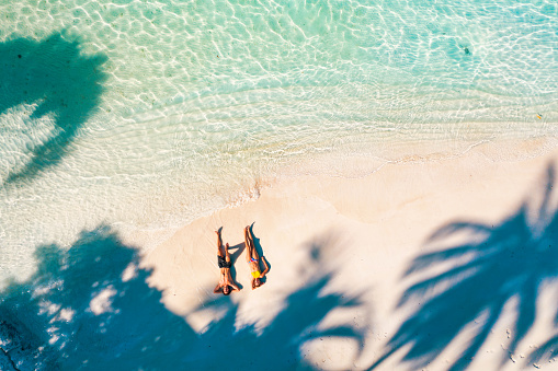 Young couple enjoying sun under palm trees in Maldives