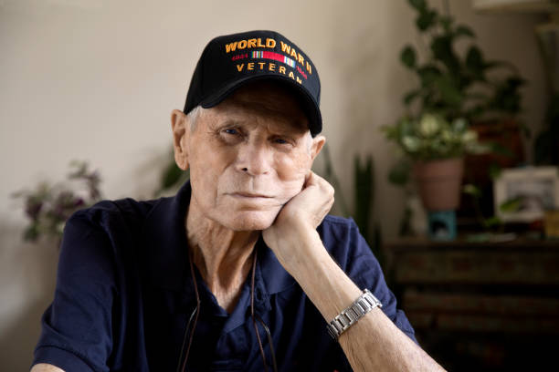 istock World War Two Veteran head resting on hand looking at camera 1271946695