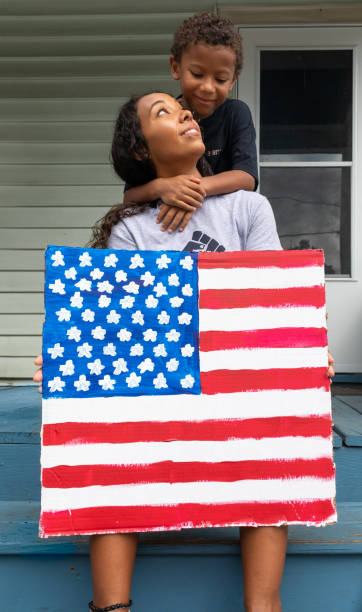Multi Ethnic Mother and Son Holding American Flag Hand-painted Sign Multi Ethnic Mother and Son Holding American Flag Hand-painted Sign anti racism photos stock pictures, royalty-free photos & images