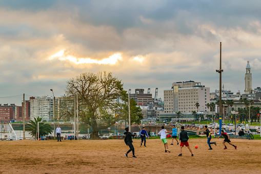 MONTEVIDEO, URUGUAY, AUGUST - 2020 - Teens playing soccer at ground field at ciudad vieja neighborhood, montevideo, uruguay