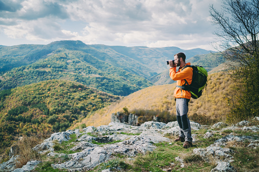 Young man taking photos on the mountain top