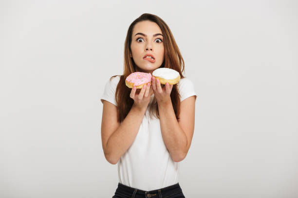 istock Hungry young lady holding donuts 1271954268