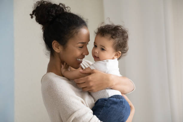 affectionate millennial biracial mama tragen auf händen lustige skid. - humor mother 20s adult stock-fotos und bilder