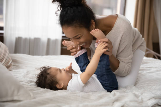 istock Smiling affectionate biracial mother having fun with kid in bedroom. 1271954672