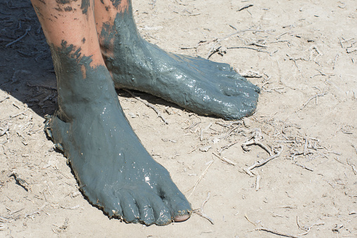 Feet of female feet in healing mud. Cosmetology and balneology for human health.