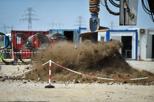 máquina de excavación industrial excavando suelo en un sitio de construcción - earth mover digging land bulldozer fotografías e imágenes de stock