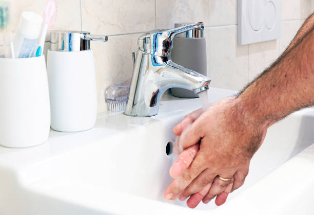 istock a man washing his hands in a white ceramic sink 1271956024