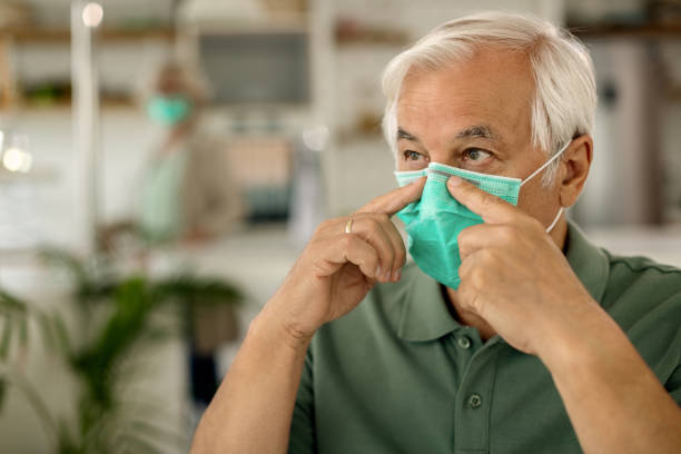istock Senior man adjusting protective mask on his face due to coronavirus epidemic. 1271961350