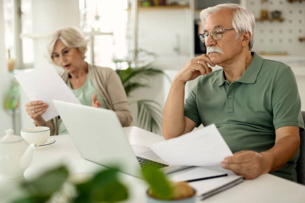 istock Mature man using laptop while going through home finances with his wife. 1271961392
