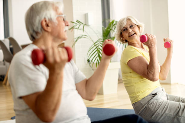 istock Happy senior couple exercising with hand weights at home. 1271962484