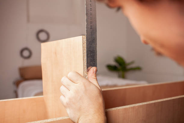 istock A man measures a ruler shelf for a cabinet 1271962621