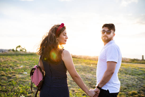 istock A young couple holding hands and looking back 1271963771