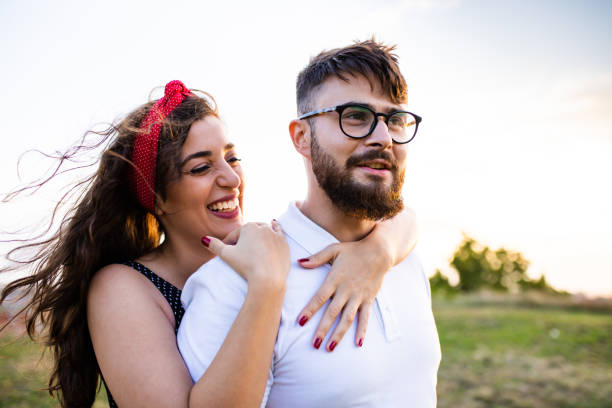 istock A beautiful woman laughing while hugging her boyfriend from behind 1271963804