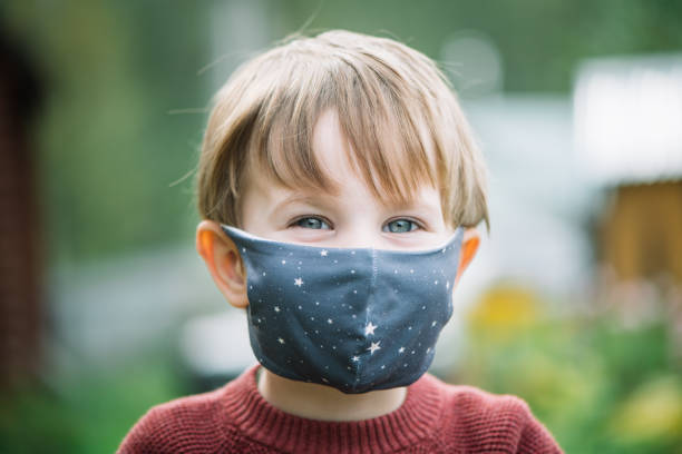 istock Little boy wearing protective face mask outdoors 1271964035