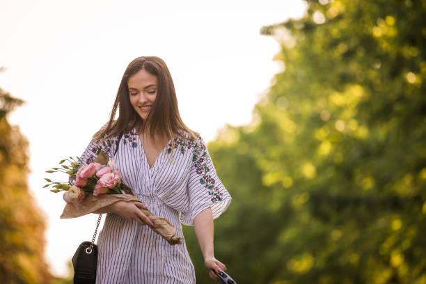 istock Carrying flowers with one hand while holding her dog's leash 1271969561