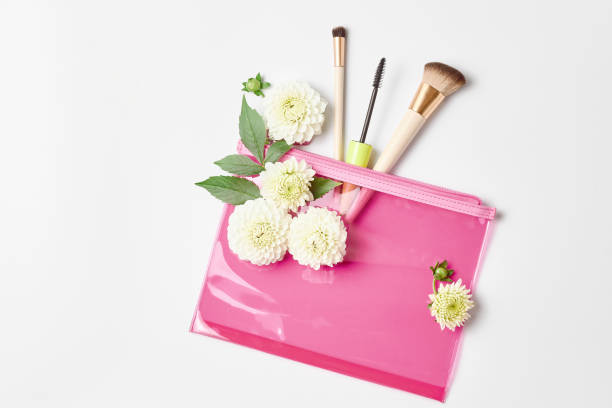 istock makeup concept. a pink cosmetic bag, makeup brushes, and fresh white flowers. flat lay, copy space 1271972944