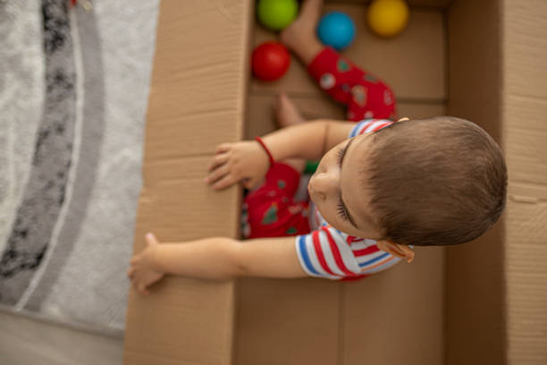 istock A baby sitting in an empty box for Christmas ornaments 1271978704