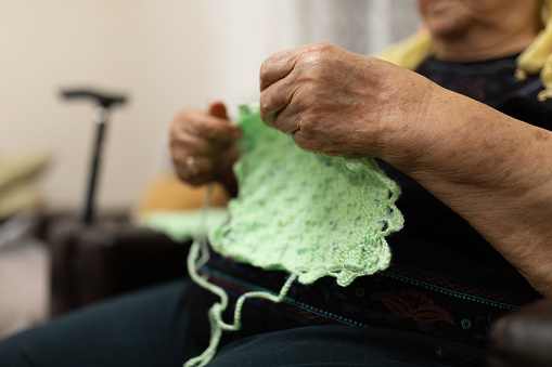 Close up on senior woman's hands knitting