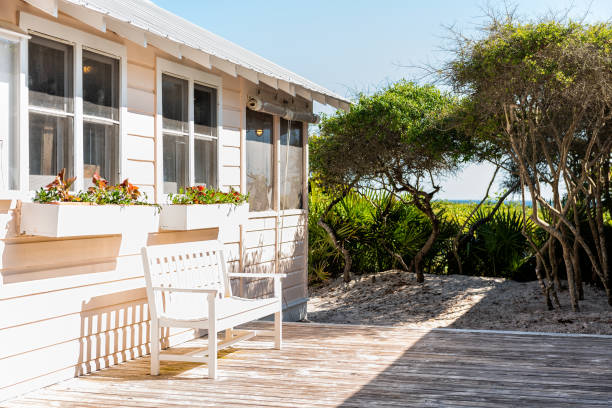 Wooden bench and cottage home house architecture in Florida beach by sand dunes during sunny day peaceful tranquil vacation Wooden bench and cottage home house architecture in Florida beach by sand dunes during sunny day peaceful tranquil vacation small florida home stock pictures, royalty-free photos & images