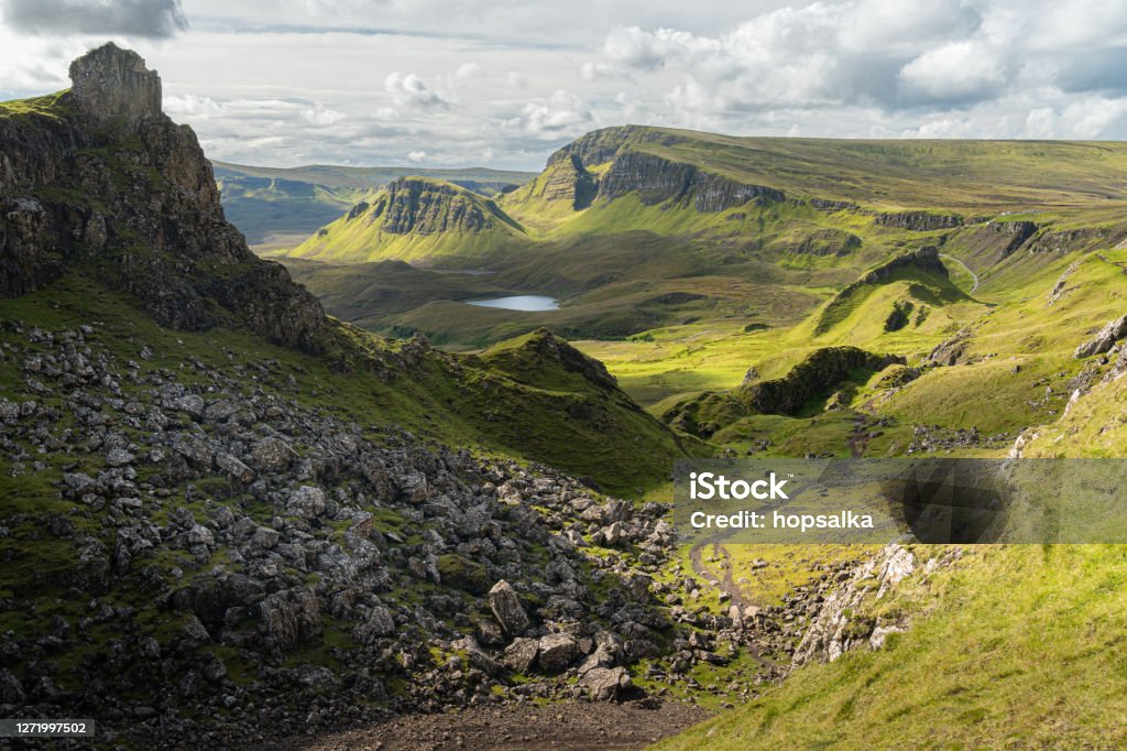 Scenic view of the Prison rocky outcrop in the Quiraing, Isle of Skye, Scotland. Beautiful area of grassy mountains covered by blooming heather in summer, hidden lochs and steep cliffs Quiraing Needle Stock Photo