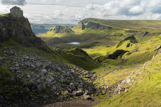 malowniczy widok na skalistą wyrostek w quiraing, wyspa skye, szkocja. piękny obszar trawiastych gór pokrytych kwitnącymi wrzosami w lecie, ukrytymi jeziorami i stromymi klifami - quiraing needle zdjęcia i obrazy z banku zdjęć