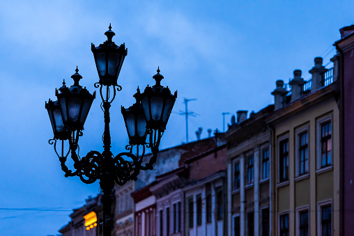 Lviv, Ukraine lantern closeup in historic Ukrainian city in old town market square with buildings architecture and blue dark evening night sky