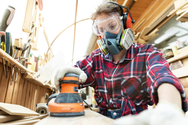 Young adult caucasian mid aged professional female carpenter grinding raw wood with orbital sander tool in carpentry diy workshop. Feminine women equality concept. Women do male hobby at workbench. joven adulto caucásico de mediana edad mujer carpintera profesional molienda de madera cruda con herramienta de lijadora orbital en taller de carpintería diy. concepto de igualdad femenina para mujeres. las mujeres hacen pasatiempo masculino en el banco