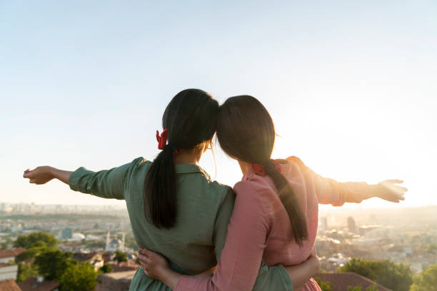 istock Two girls on sunset background. Best friends. 1272002072