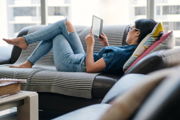 istock Young Woman Holding Ereader And Reading Ebook 1272004241