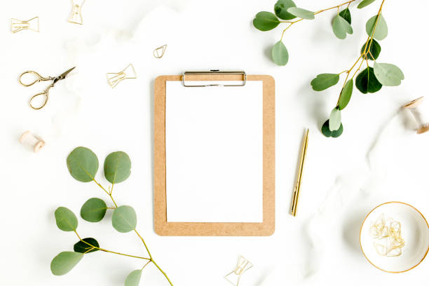 istock Workspace with clipboard and leaf eucalyptus on white background. Flat lay of home office desk, top view 1272004346