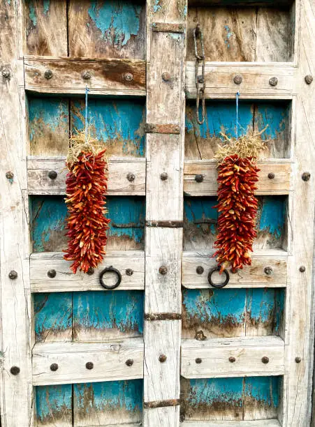 Santa Fe Style: Two Red Ristras on Antique Wood Doors. Shot in Santa Fe, NM.