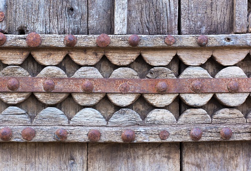 Detail from an ornate antique distressed wooden Indian door with rusty metal.