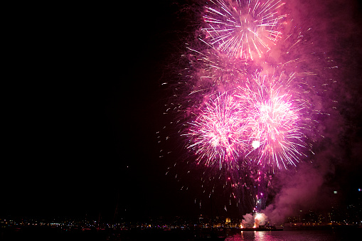 Fireworks display in purple, reflected across the water.