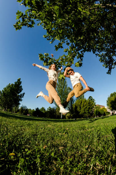 istock Happy couple jumping on the park 1272010509