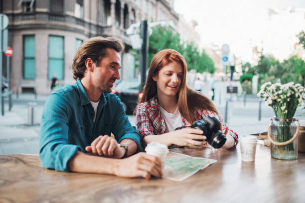 istock Couple on a journey taking a coffee break and watching their photos 1272010573