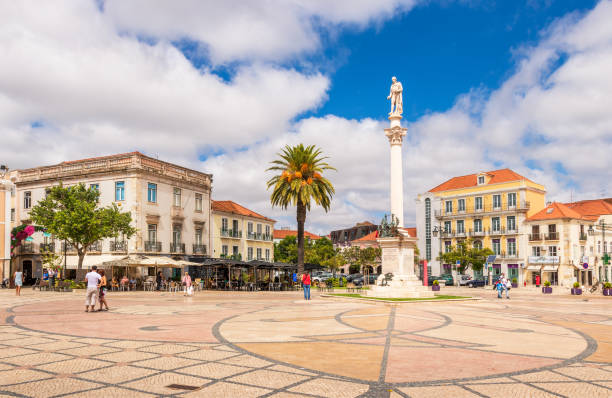 View of the Bocage square in Setubal, Portugal. Setubal, Portugal - August 28, 2020: with emphasis on the statue of the poet Bocage and around old buildings with terraces, on a summer day with some clouds. setúbal city portugal stock pictures, royalty-free photos & images